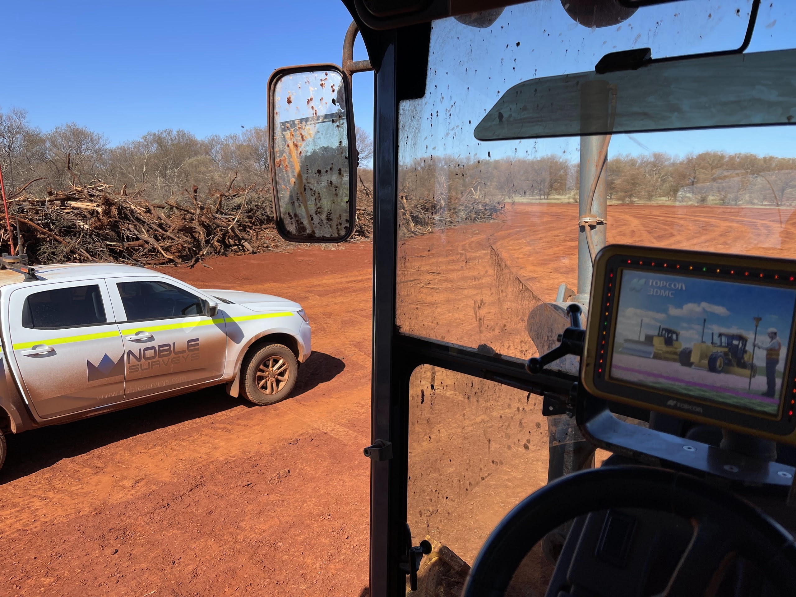 Surveyors checking stockpile volumes on a civil construction site